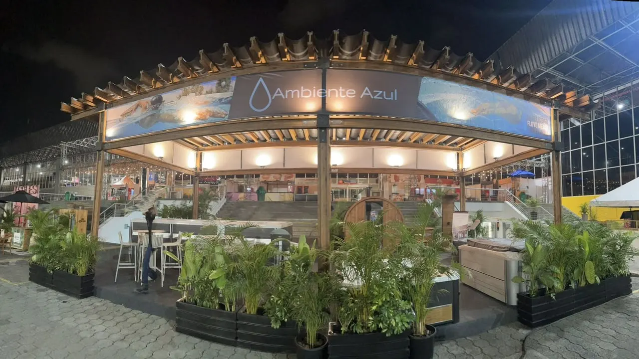 Lounge de Ambiente Azul bajo pérgola de madera con plantas tropicales