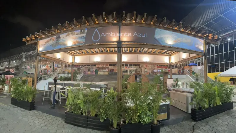 Lounge de marca bajo pérgola de madera con plantas tropicales