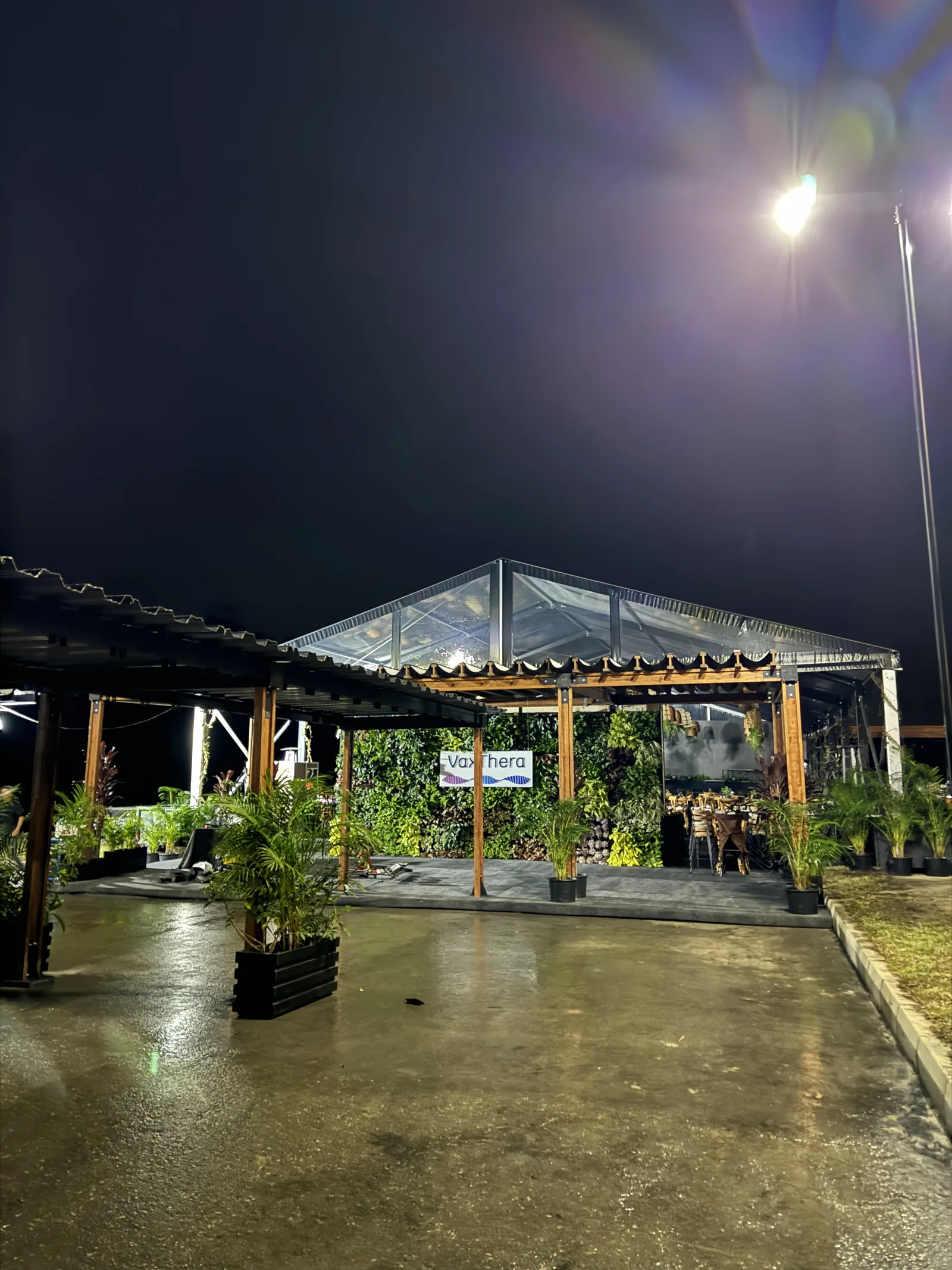 Pérgolas de madera y pabellón transparente de noche en la inauguración de la planta VaxThera