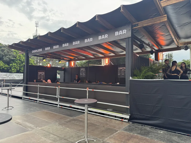 Barra de bebidas de Tomorrowland CORE bajo pérgola con lona negra