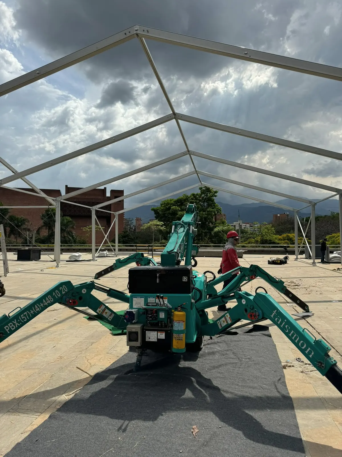 Grúa araña dentro de la estructura de aluminio de un pabellón en montaje